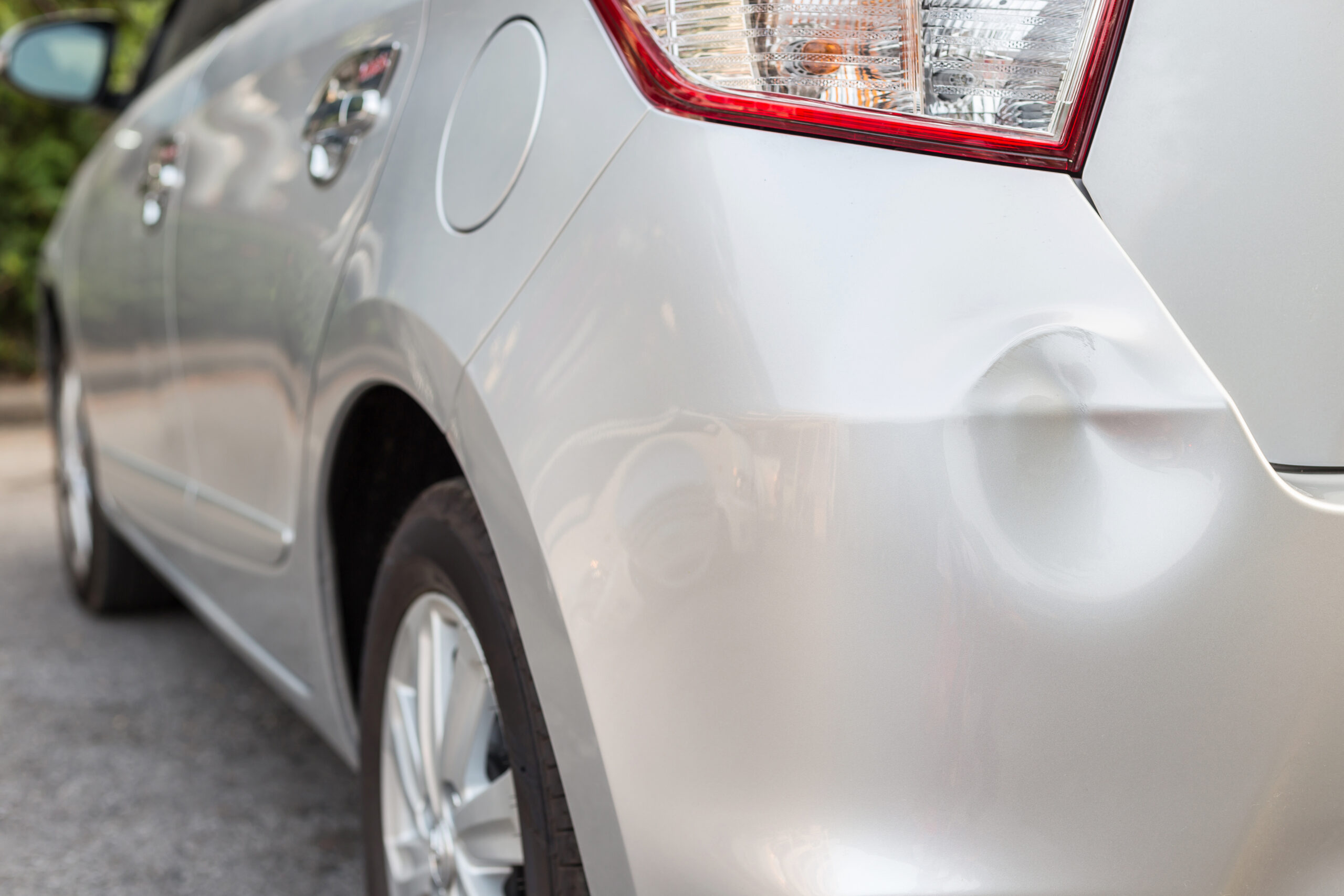 Close-up of dented vehicle panel in need of auto body repair in Pasco.