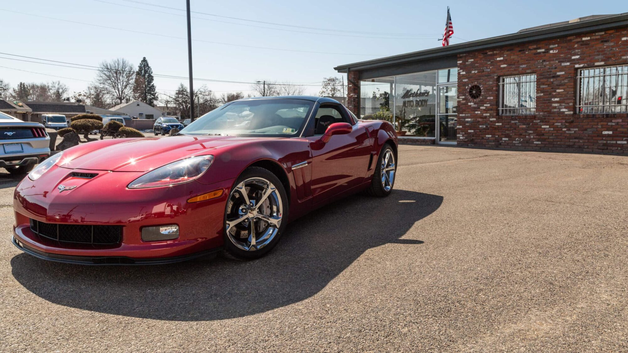 Red corvette parked in front of Mathews Auto Body shop, after auto body repairs and collision repairs